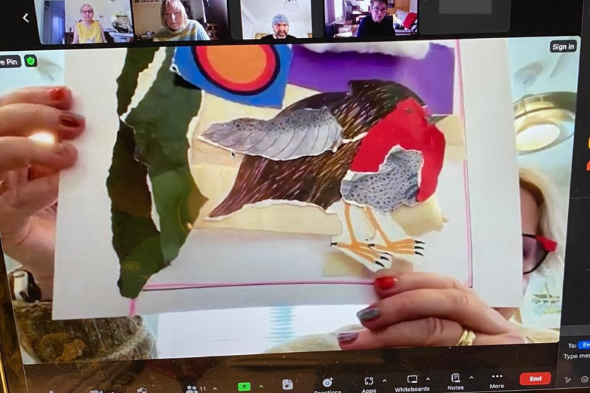 A laptop screen showing a collage of a robin being held up by a person who is mainly obscured by the collage.