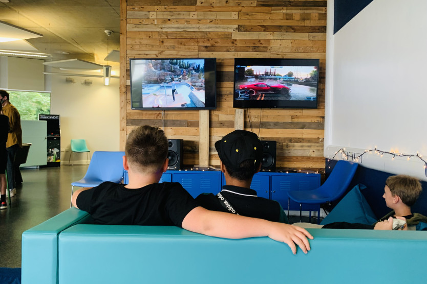 Young people sat on the sofa playing video games